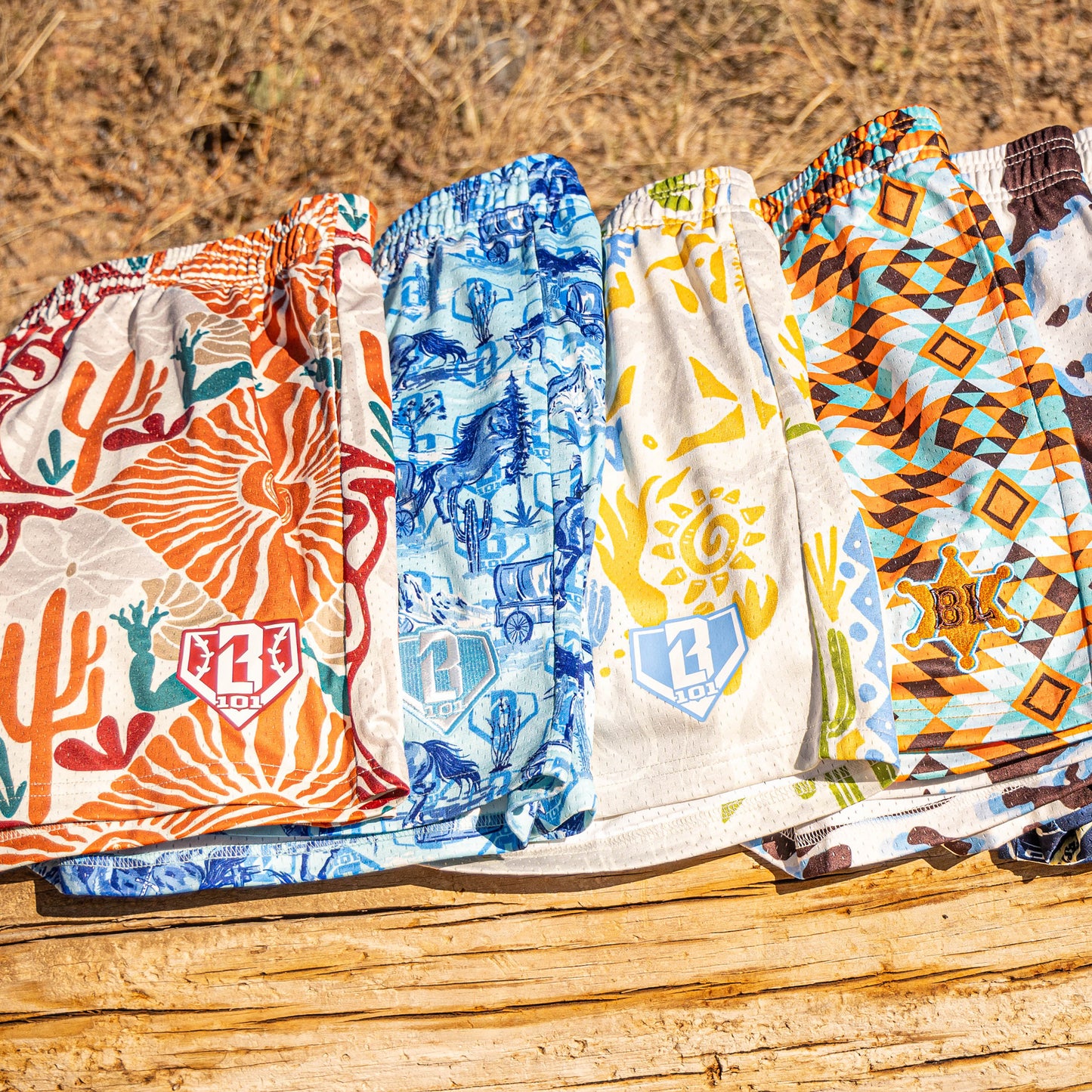 Five patterned shorts laid out on a wooden surface