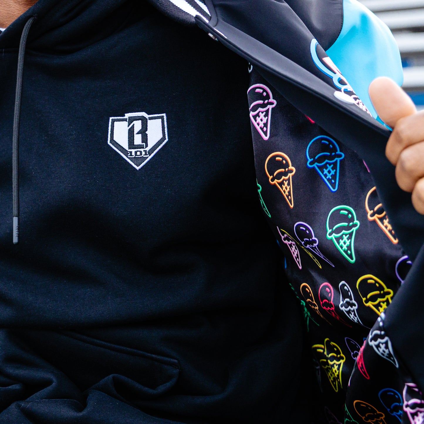 Black hoodie with a BL101 logo on the chest and jacket with colorful ice cream cone patterns on the inside.