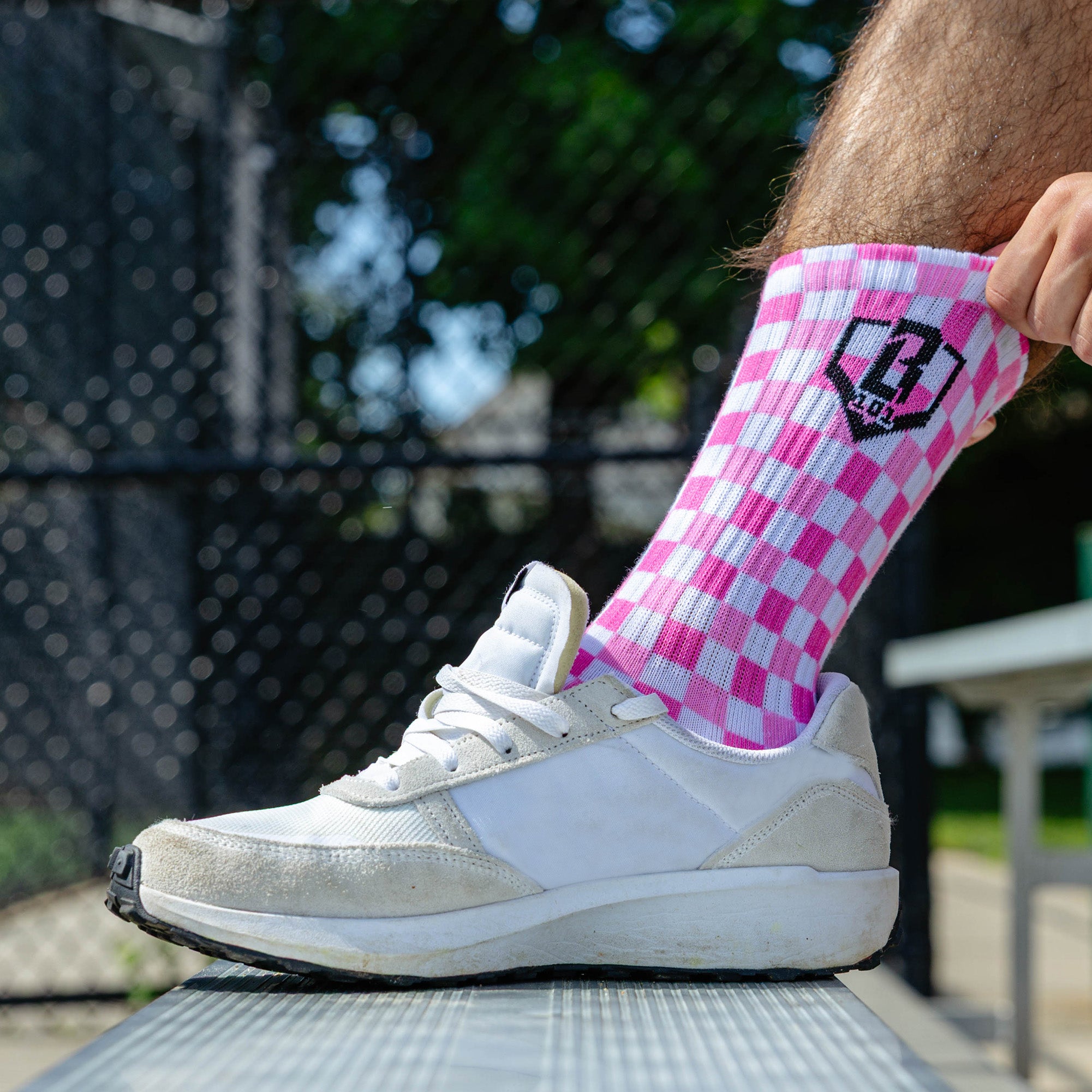 Adult model wearing multi-color socks with "Checker Print Performance  3-Pack" design