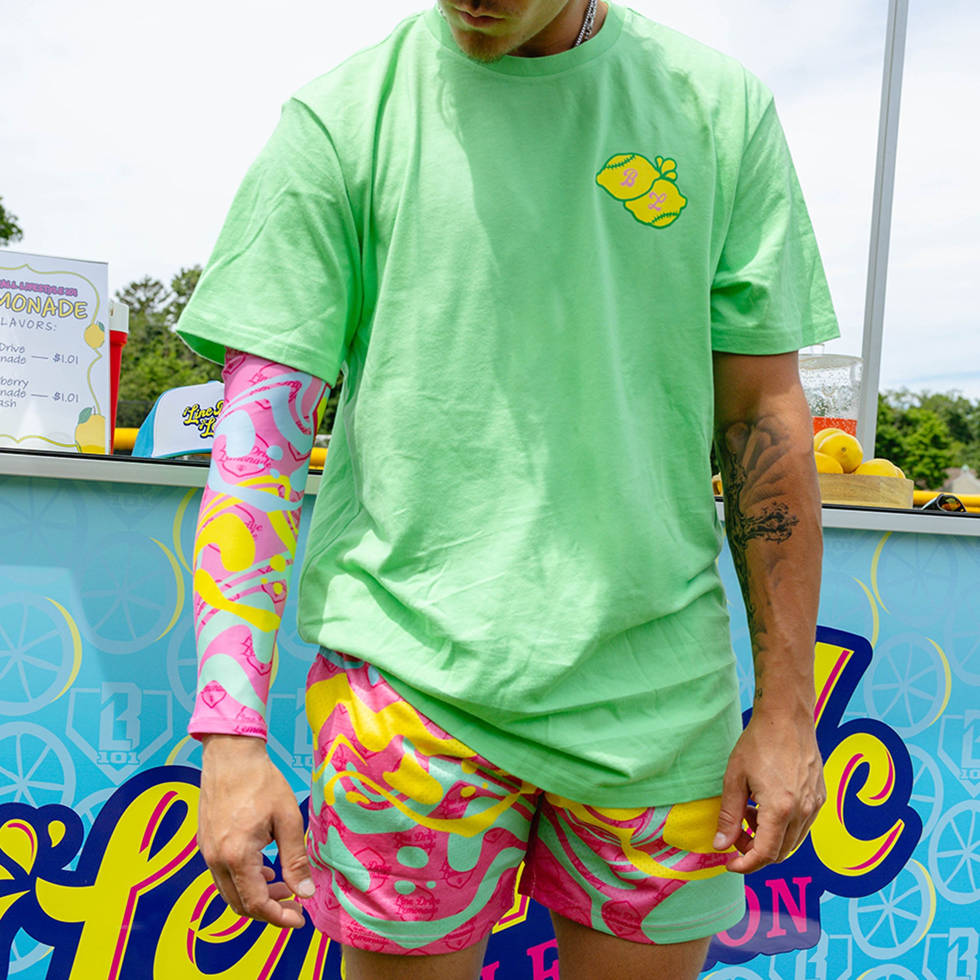 Youth model wearing pink youth arm sleeve with "Lemon Burst" design