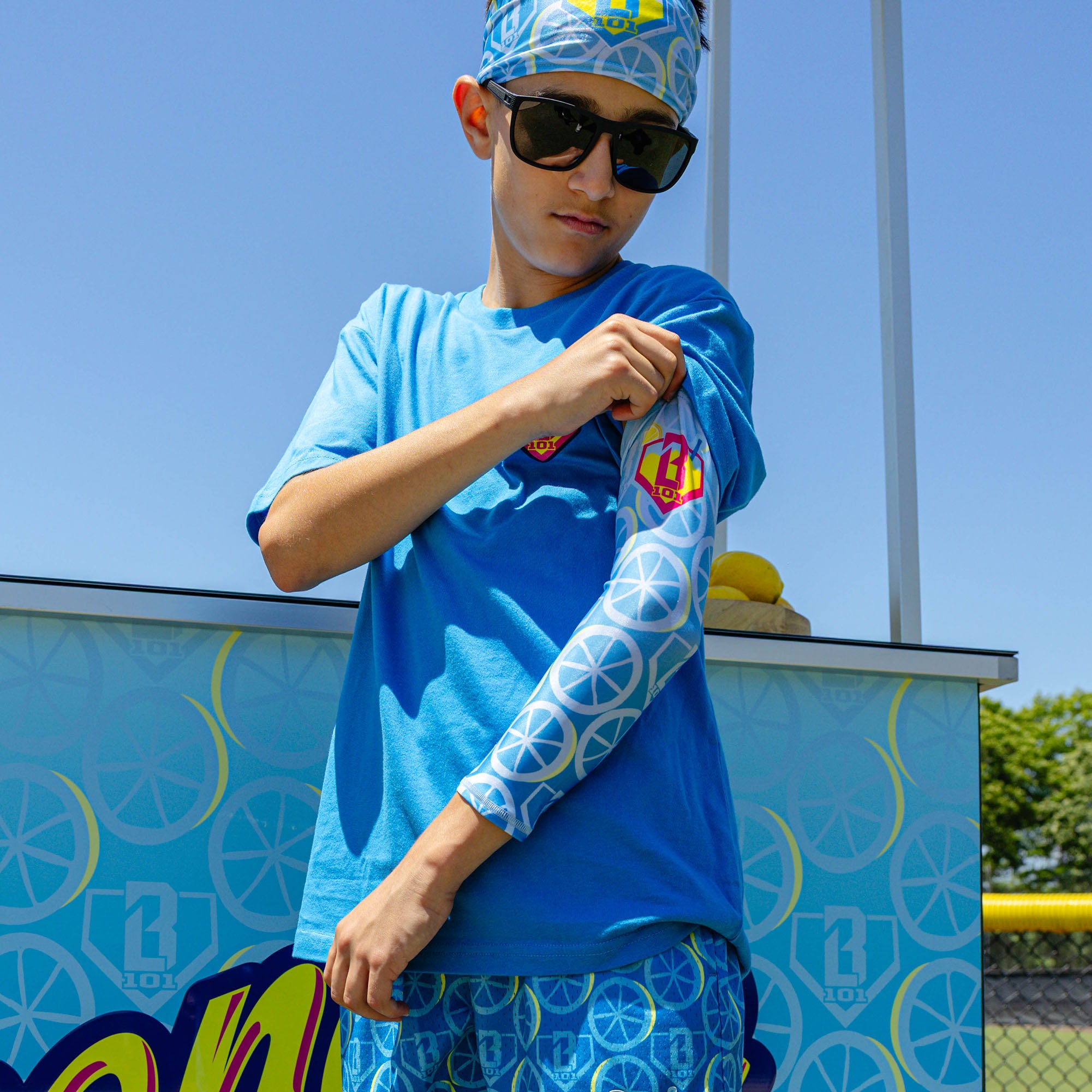 Adult model wearing blue arm sleeve with "Lemonade Splash" design