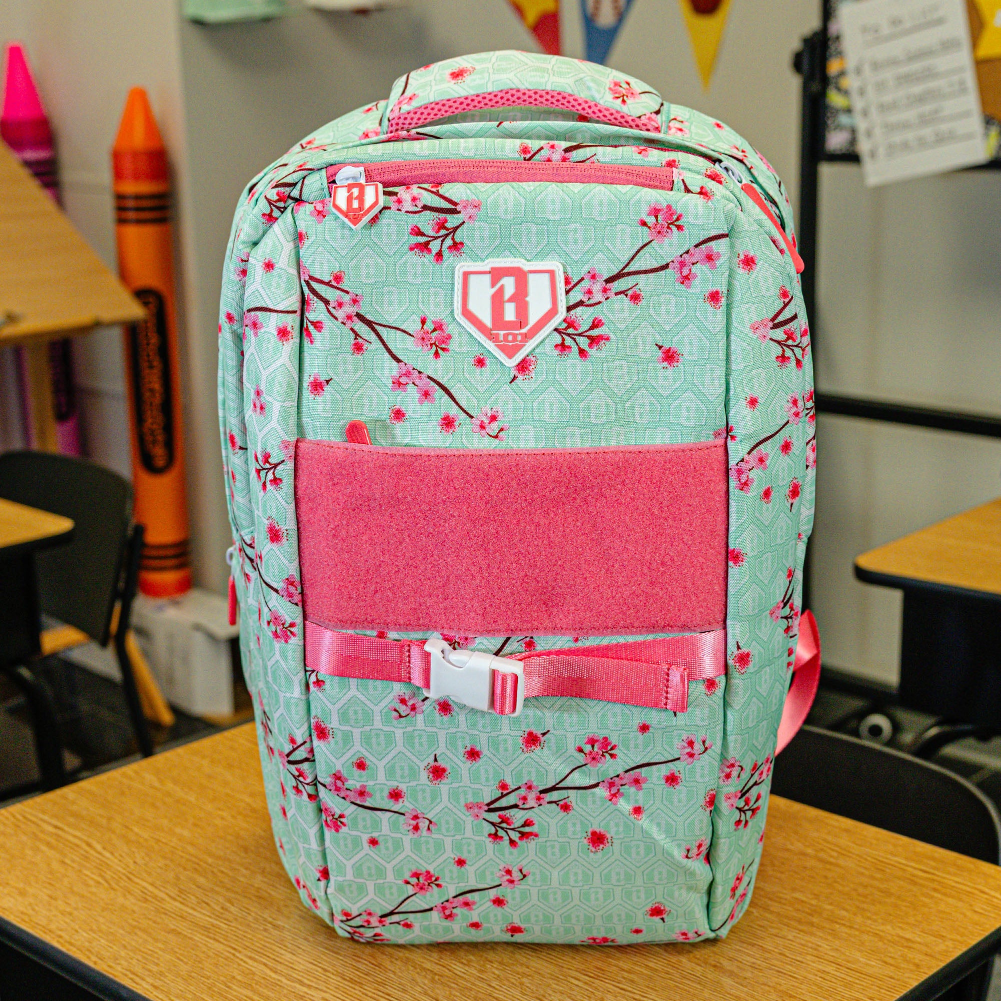 Green backpack with "Cherry Blossoms SZN 2" design — back view