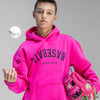 Person wearing a bright pink hoodie with upside down 'BASEBALL LIFESTYLE' text, holding a pink baseball glove against a gray background.
