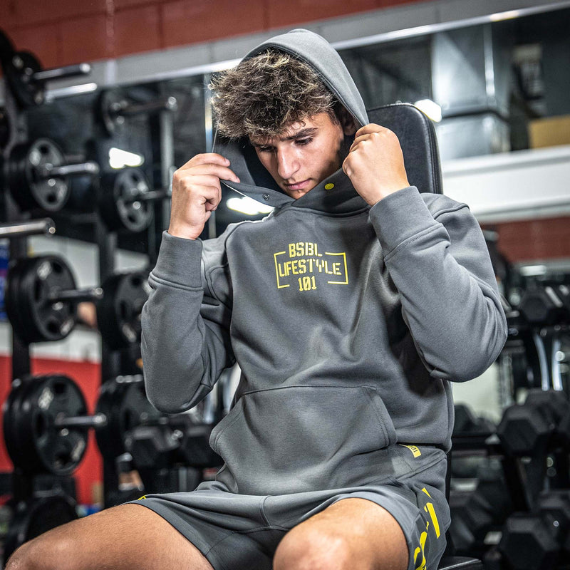Person wearing gray hoodie with yellow 'Baseball Lifestyle 101' text and branding