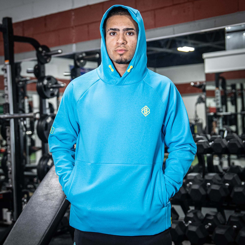 Person wearing a blue hoodie with a yellow BL101 logo in a gym setting