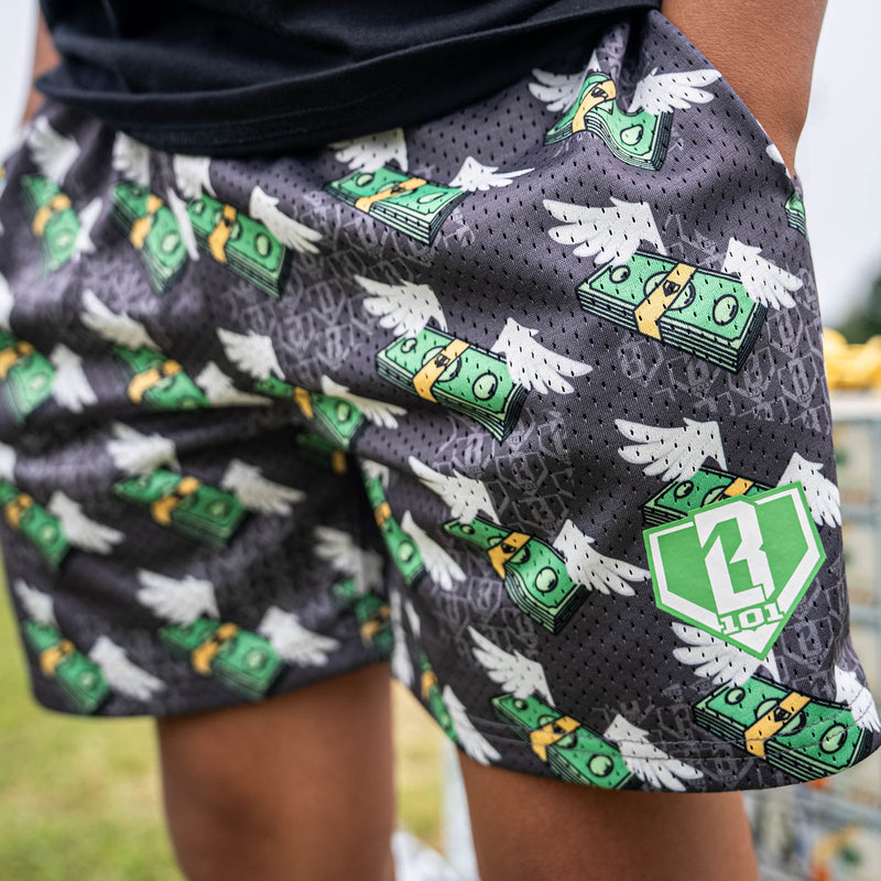 Person wearing gray shorts with green and white money with wings pattern 