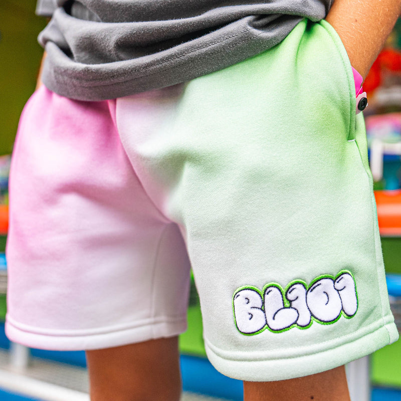 Green and pink shorts with 'BL101' logo worn by a person
