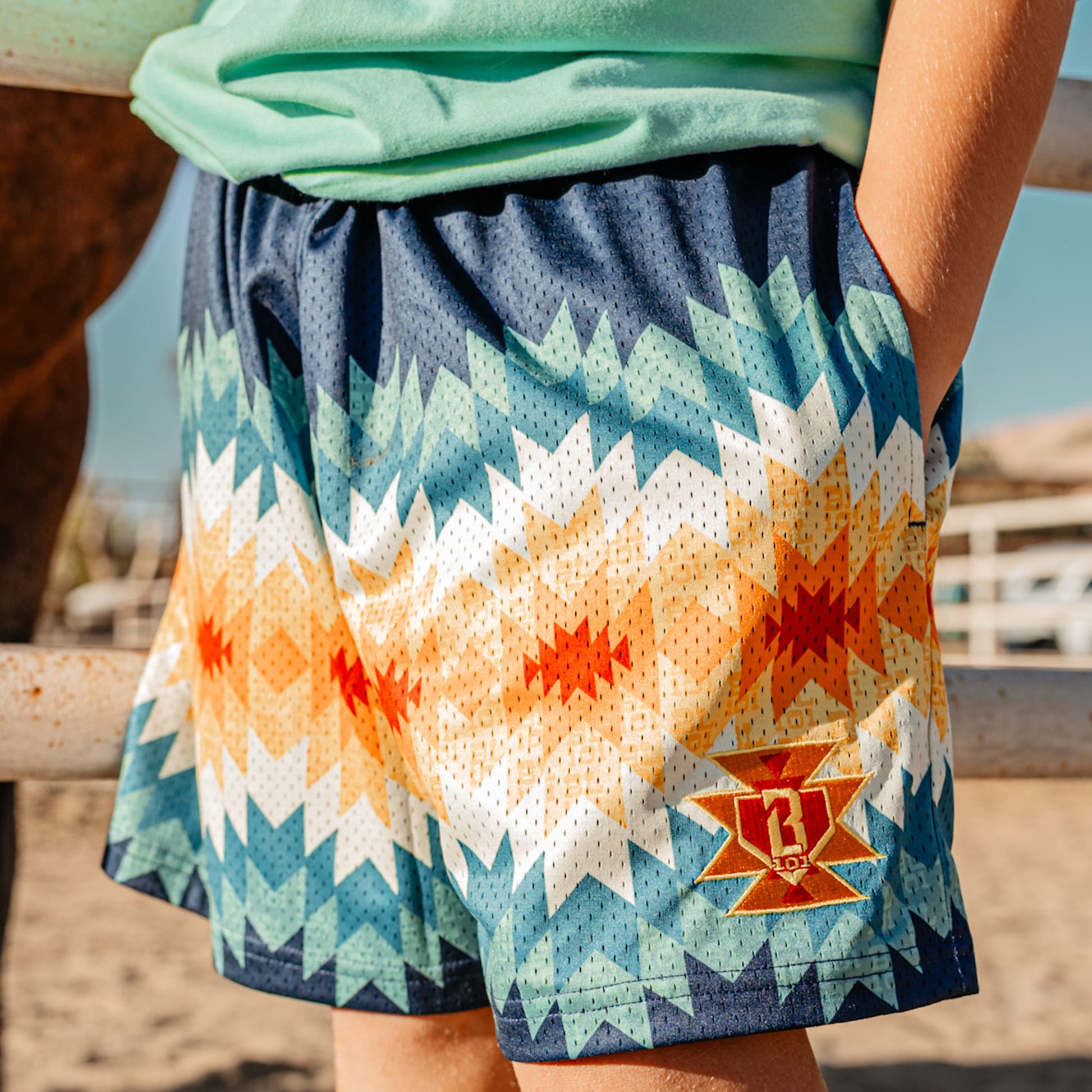 Person wearing a colorful patterned shorts with a red and yellow BL101 logo