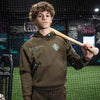 Person wearing a brown hoodie with a BL101 logo, holding a baseball bat in an indoor sports facility.