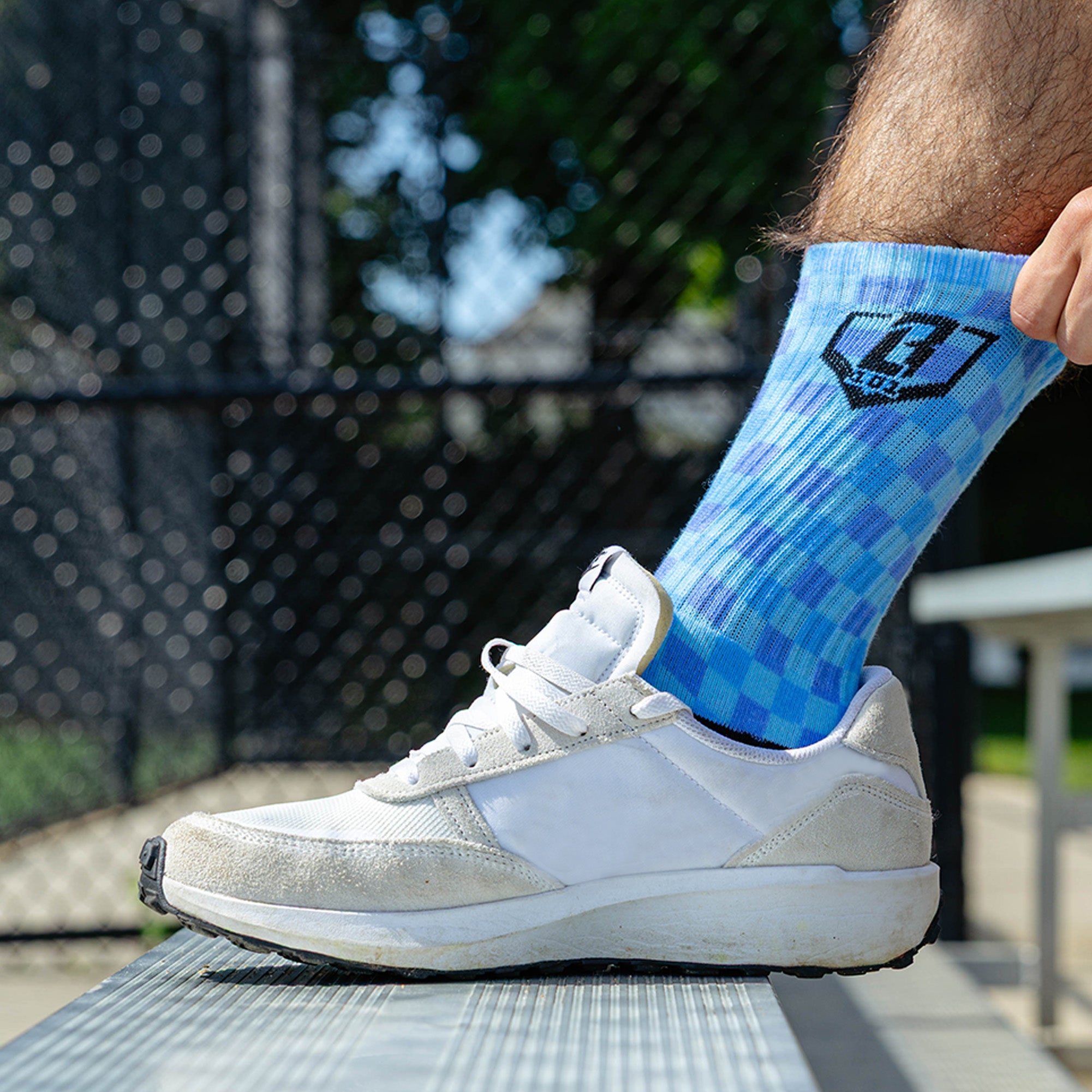 Adult model wearing multi-color socks with "Checker Print Performance  3-Pack" design