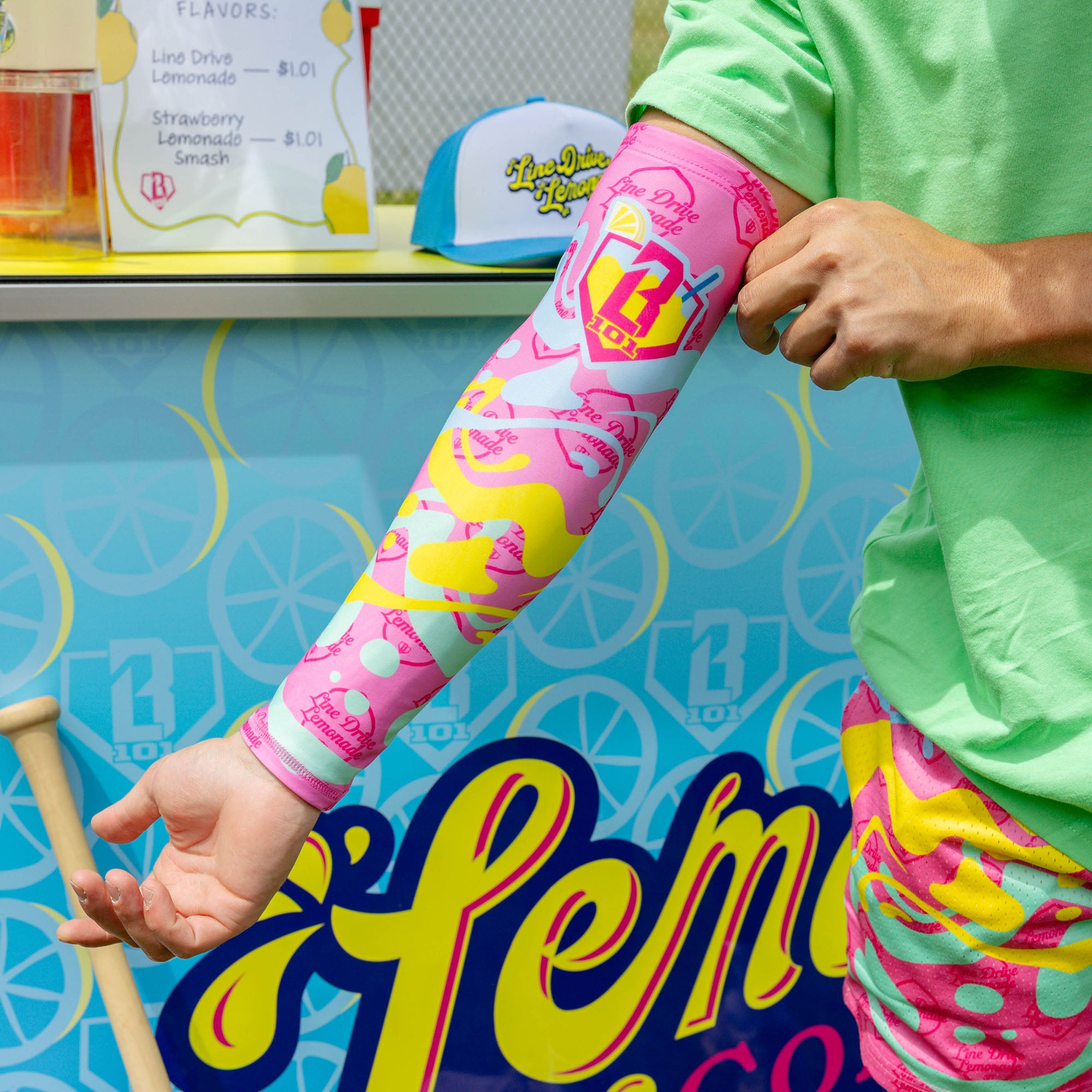 Youth model wearing pink youth arm sleeve with "Lemon Burst" design