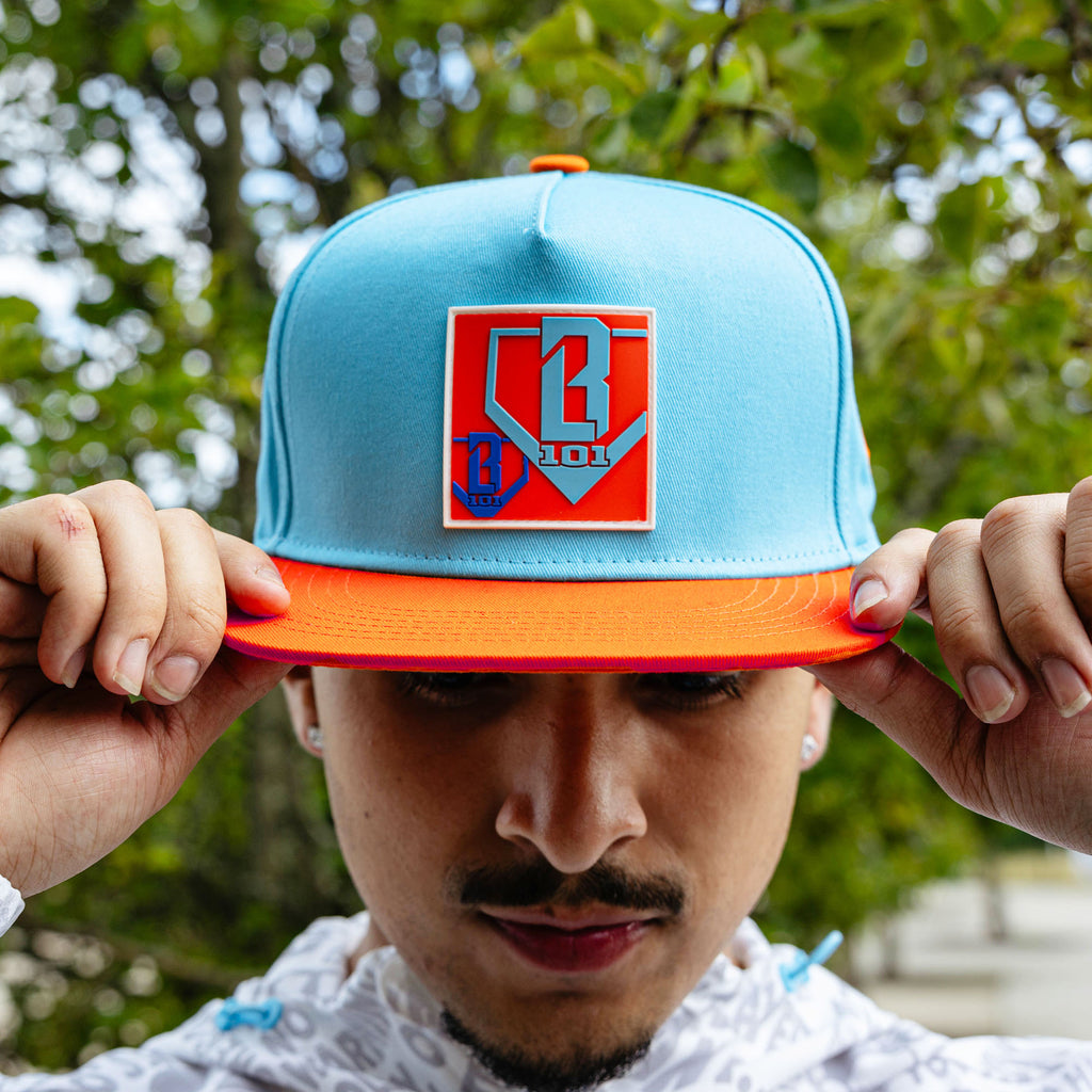 Adult model wearing blue hat with "Trash Talk" design