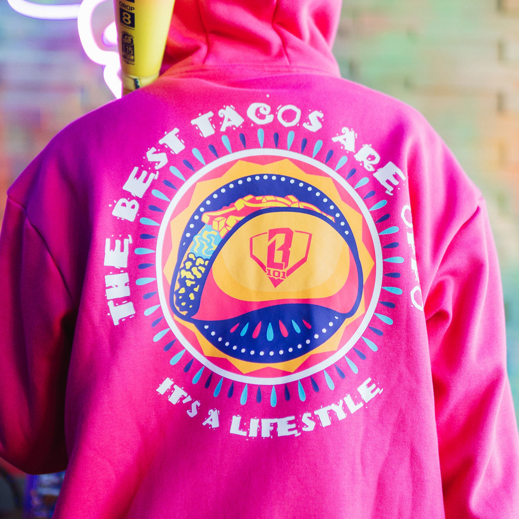 Pink hoodie with a colorful taco graphic and 'The Best Tacos are Oppo It's a Lifestyle' text on the back against a white background