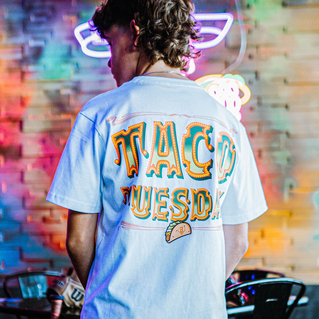 Person wearing a white t-shirt with 'Taco Tuesday' graphic design on a white background