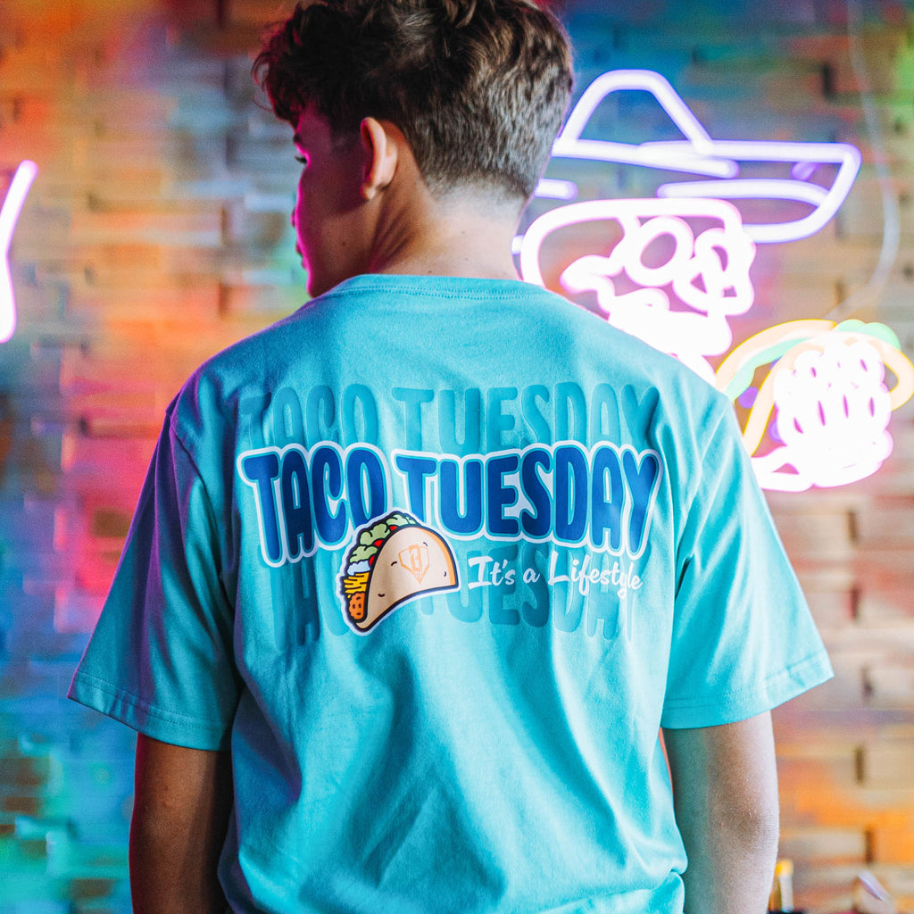 Person wearing teal t-shirt with a taco graphic and 'Taco Tuesday It's a lifestyle' text