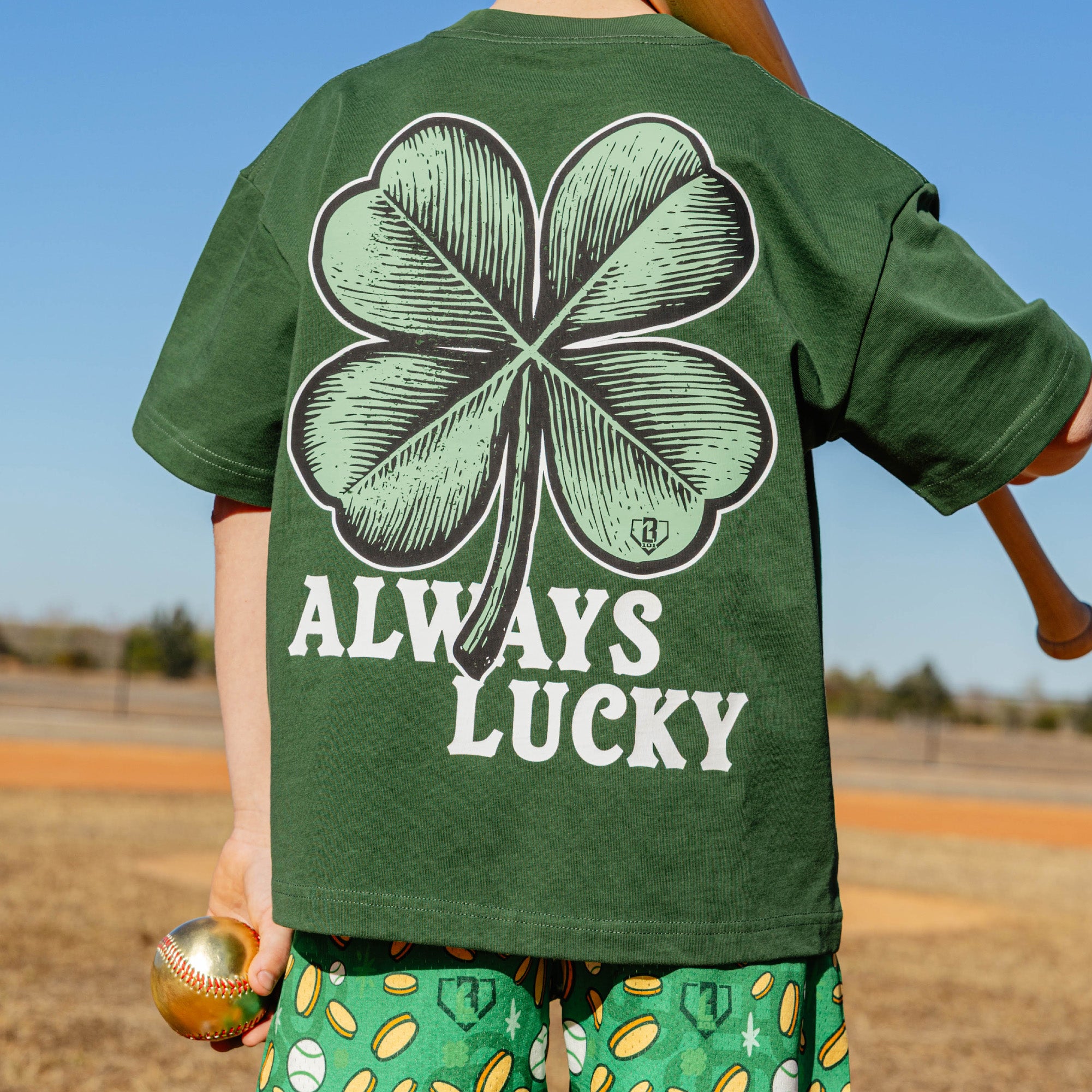 Person wearing a green t-shirt with a four-leaf clover design and 'Always Lucky' text, standing outdoors.