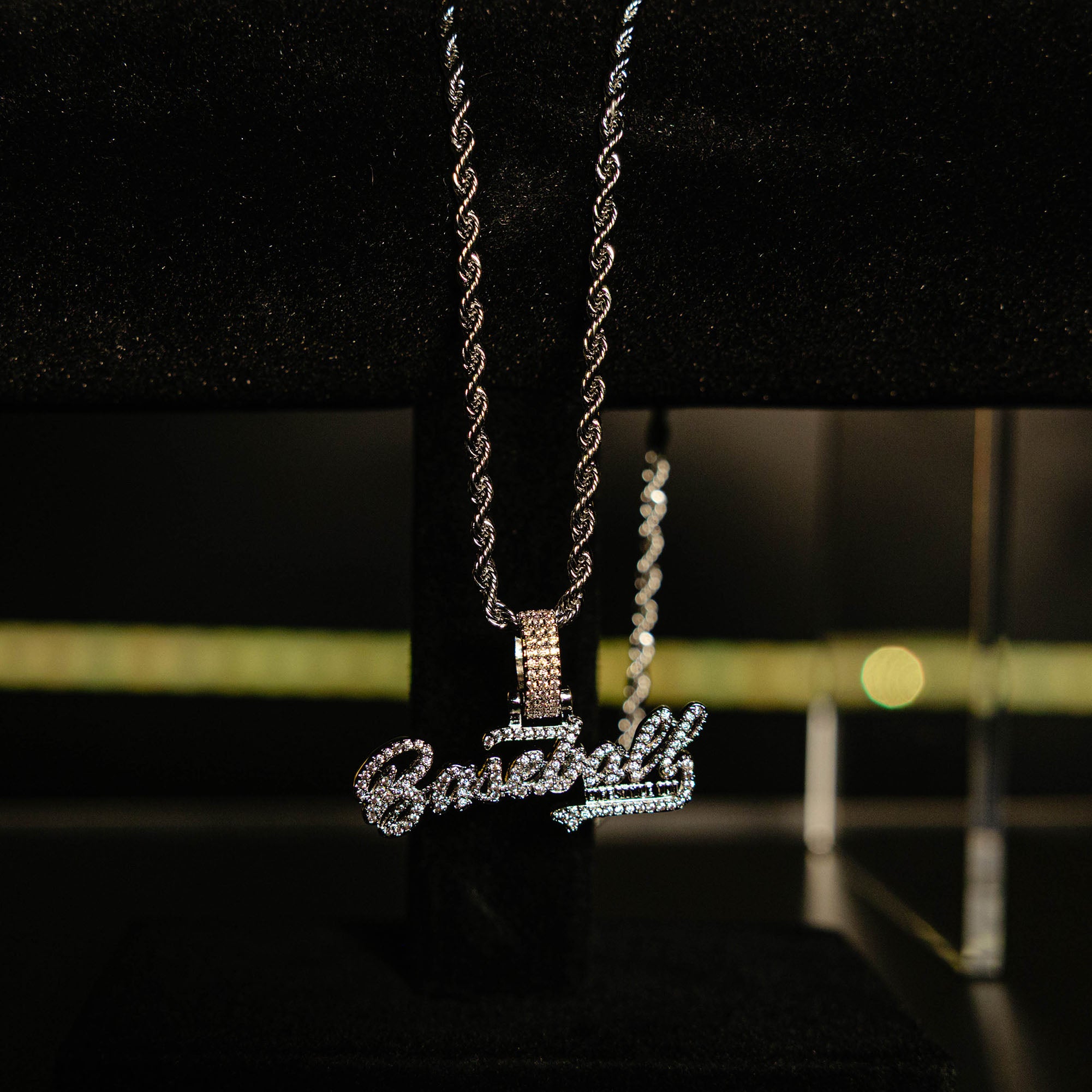 White Gold BL101 Established necklace hanging on a display stand against a black background