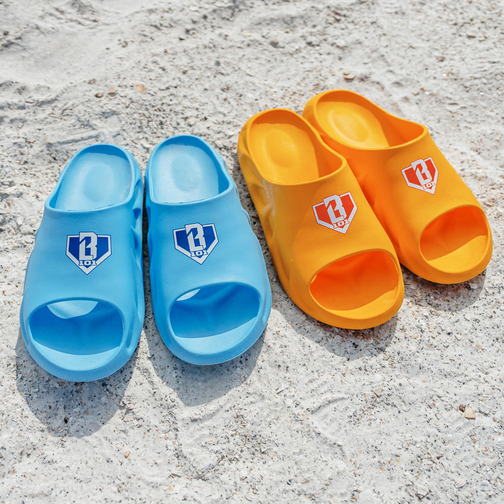 BL101 light blue slides and yellow slides side by side on sand.