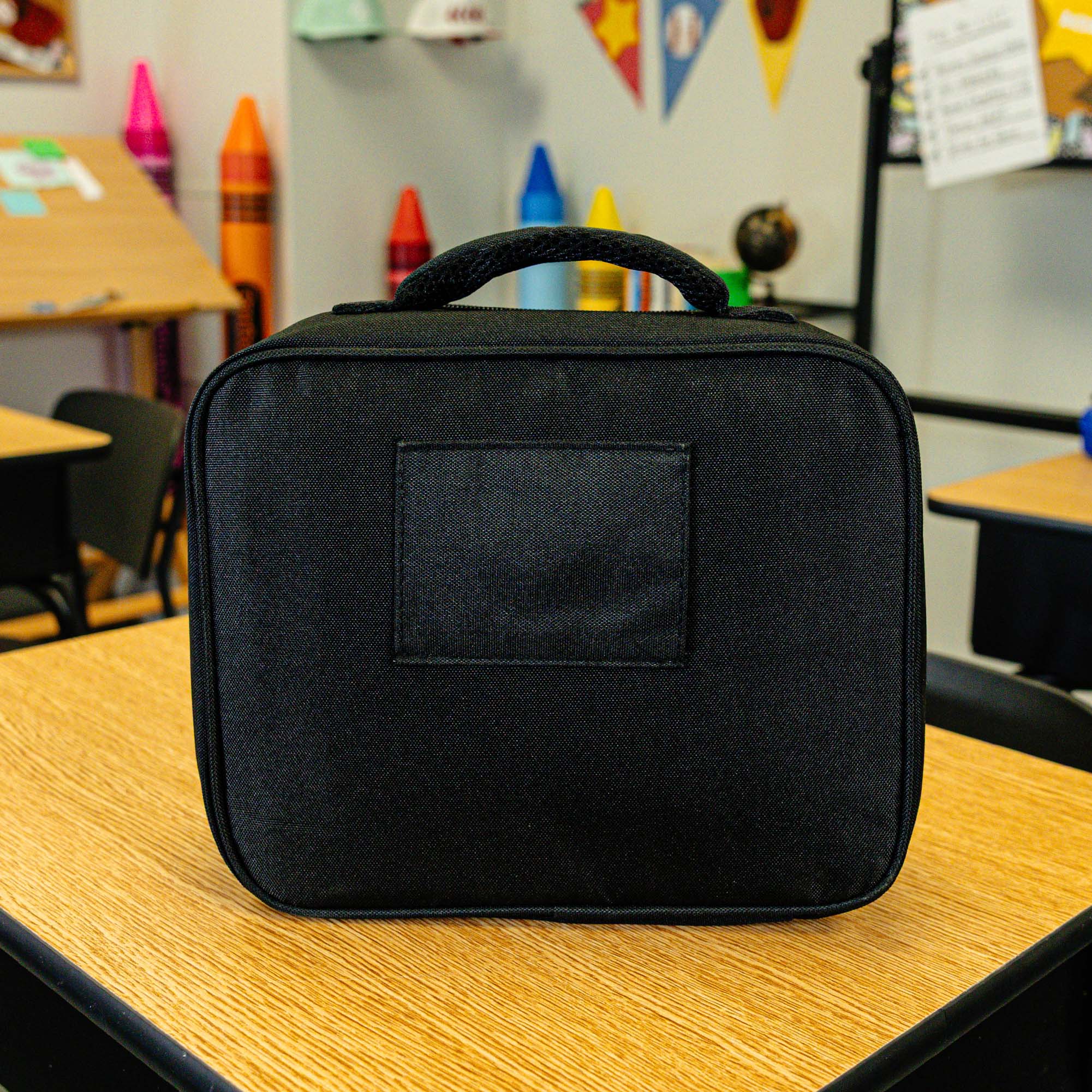 Adult model wearing black lunch box with "SZN 2" design