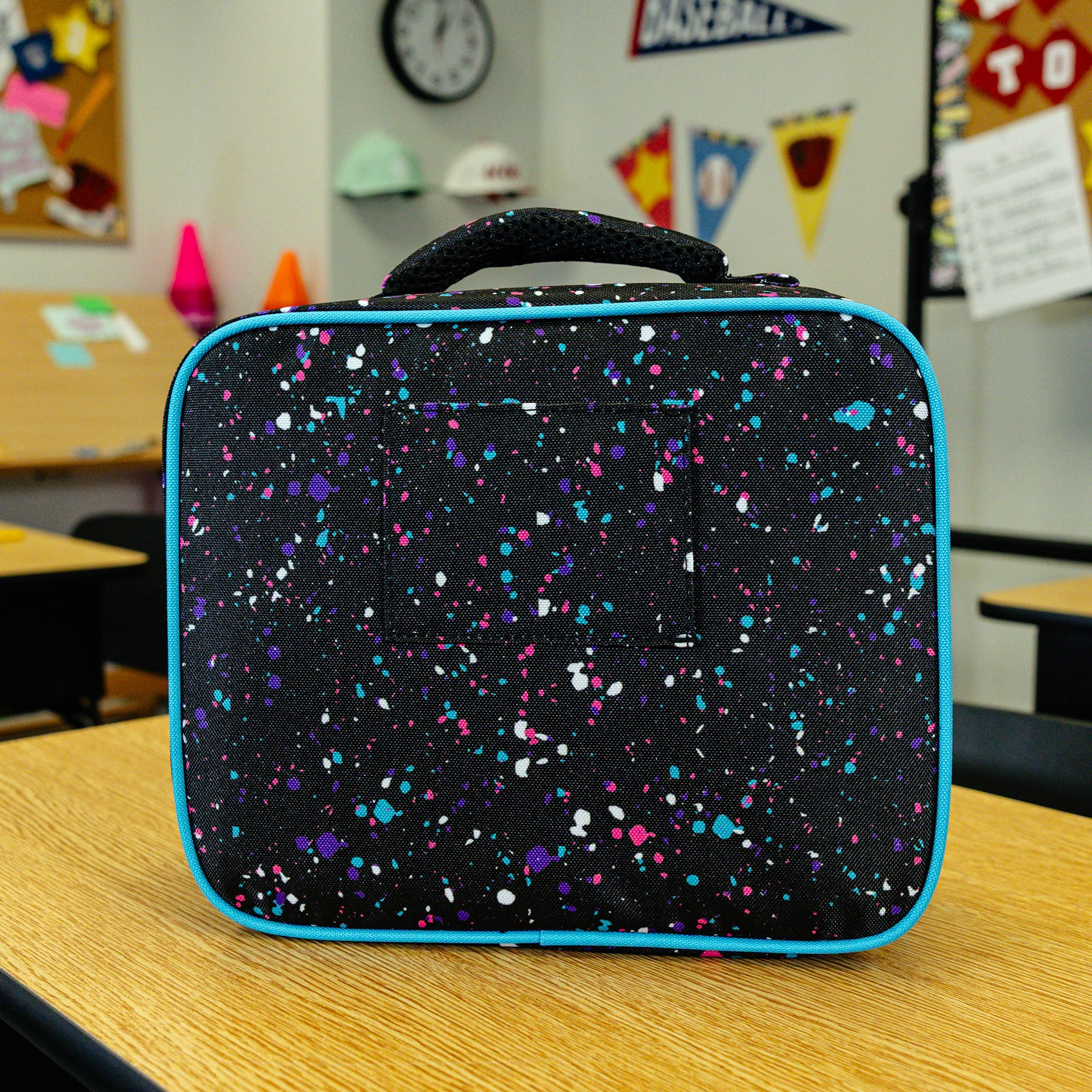 Adult model wearing black lunch box with "Splatter SZN 2" design