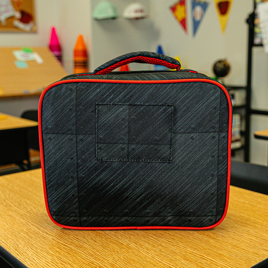 Adult model wearing multi-color lunch box with "Unit 101 SZN 2" design
