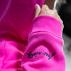 Close-up of a pink sweatshirt with 'free ninety' text on the sleeve.