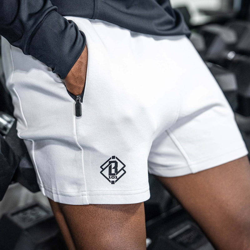 Person wearing white shorts with black BL101 logo on a white background