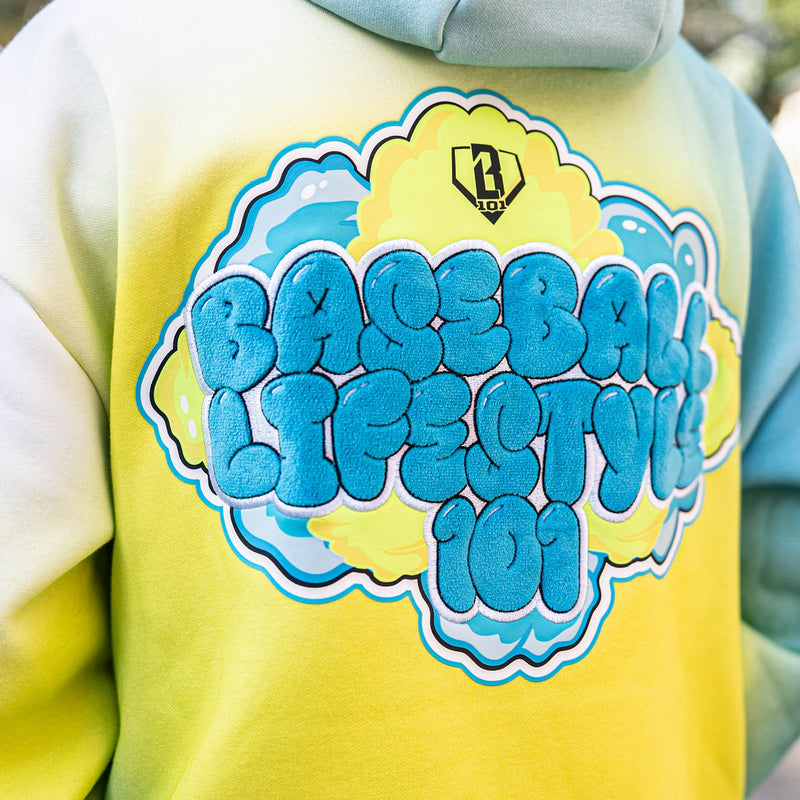 Yellow hoodie with blue BL101 logo on a blurred background