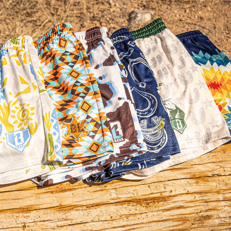 Six desert and cowboy patterned shorts on a wooden surface