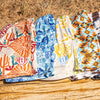 Five patterned shorts laid out on a wooden surface