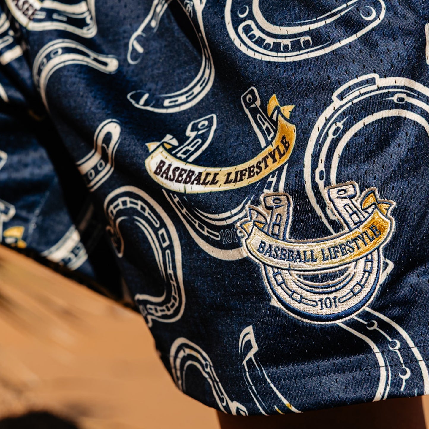 Close-up of blue shorts with horseshoe and baseball lifestyle text