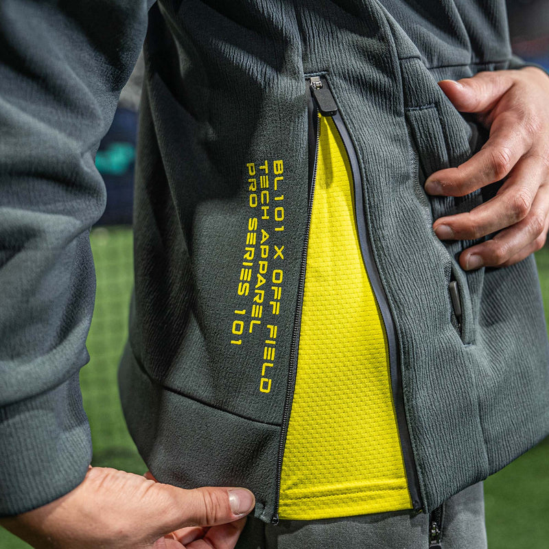Gray jacket with yellow interior and BL101 branding on a blurred outdoor background