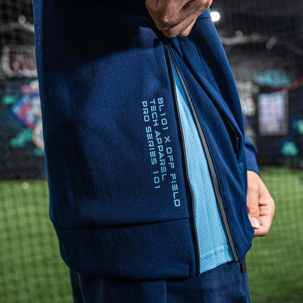 Blue athletic jacket with BL101 branding on a blurred sports arena background