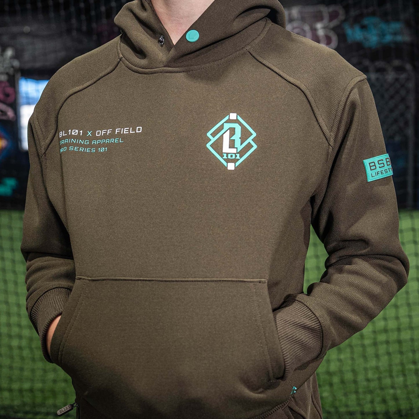 Brown hoodie with BL101 logo on a blurred background