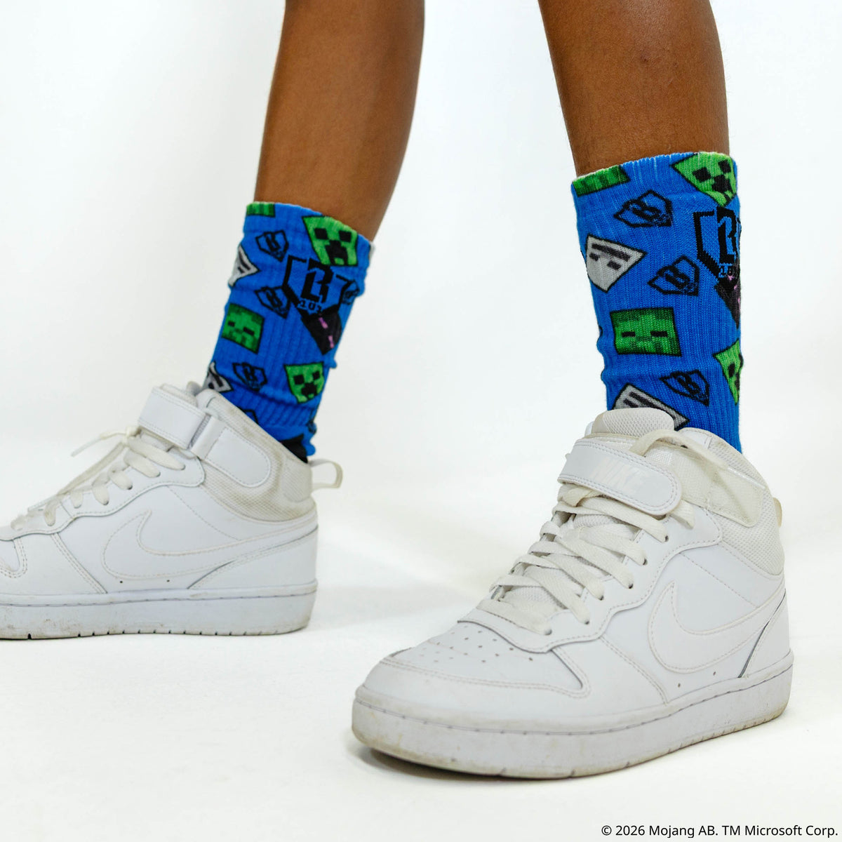 Adult model wearing multi-color socks with "BL101 X Minecraft Performance 3-Pack" design