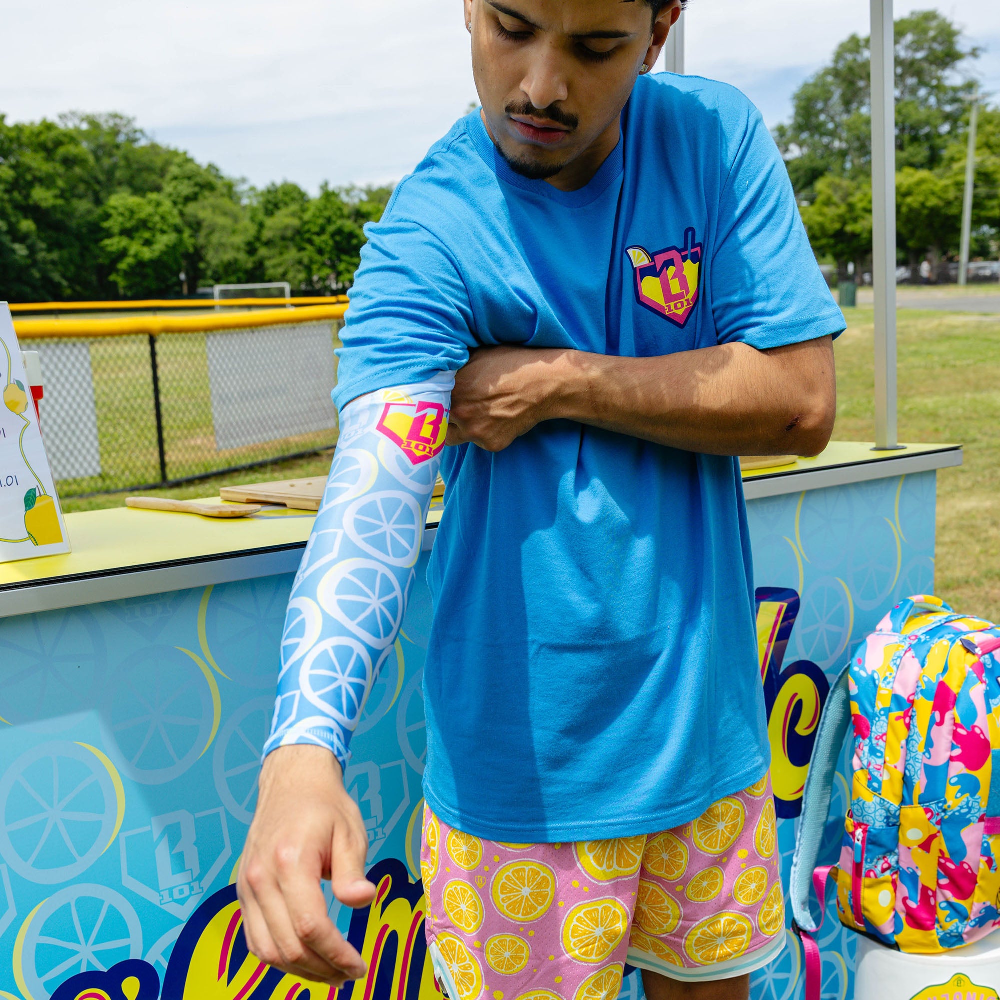 Adult model wearing blue arm sleeve with "Lemonade Splash" design