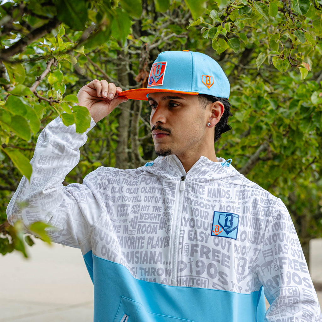Adult model wearing blue hat with "Trash Talk" design