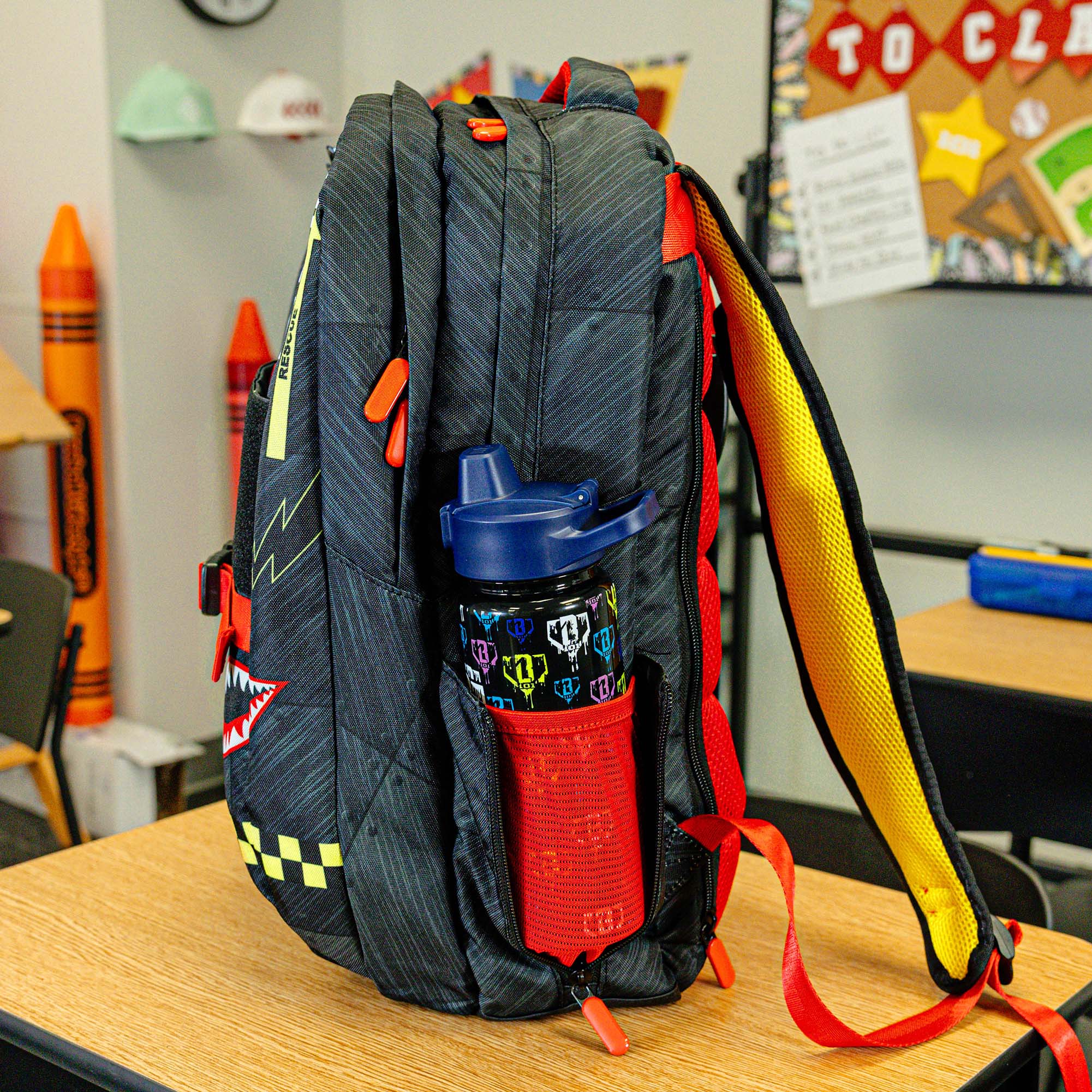 Adult model wearing multi-color backpack with "Unit 101 SZN 2" design