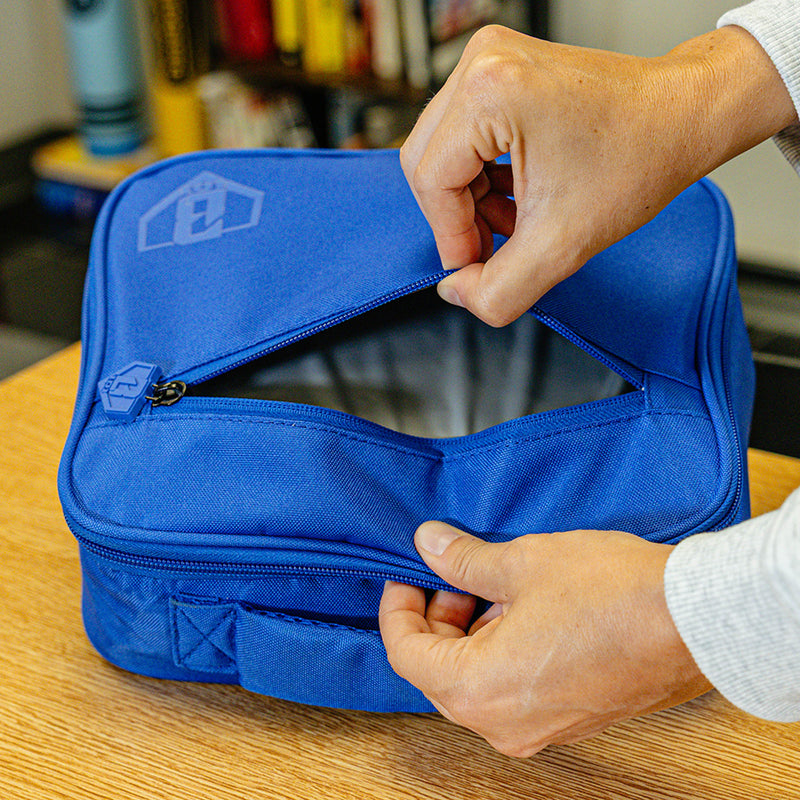 Adult model wearing blue lunch box with "SZN 2" design