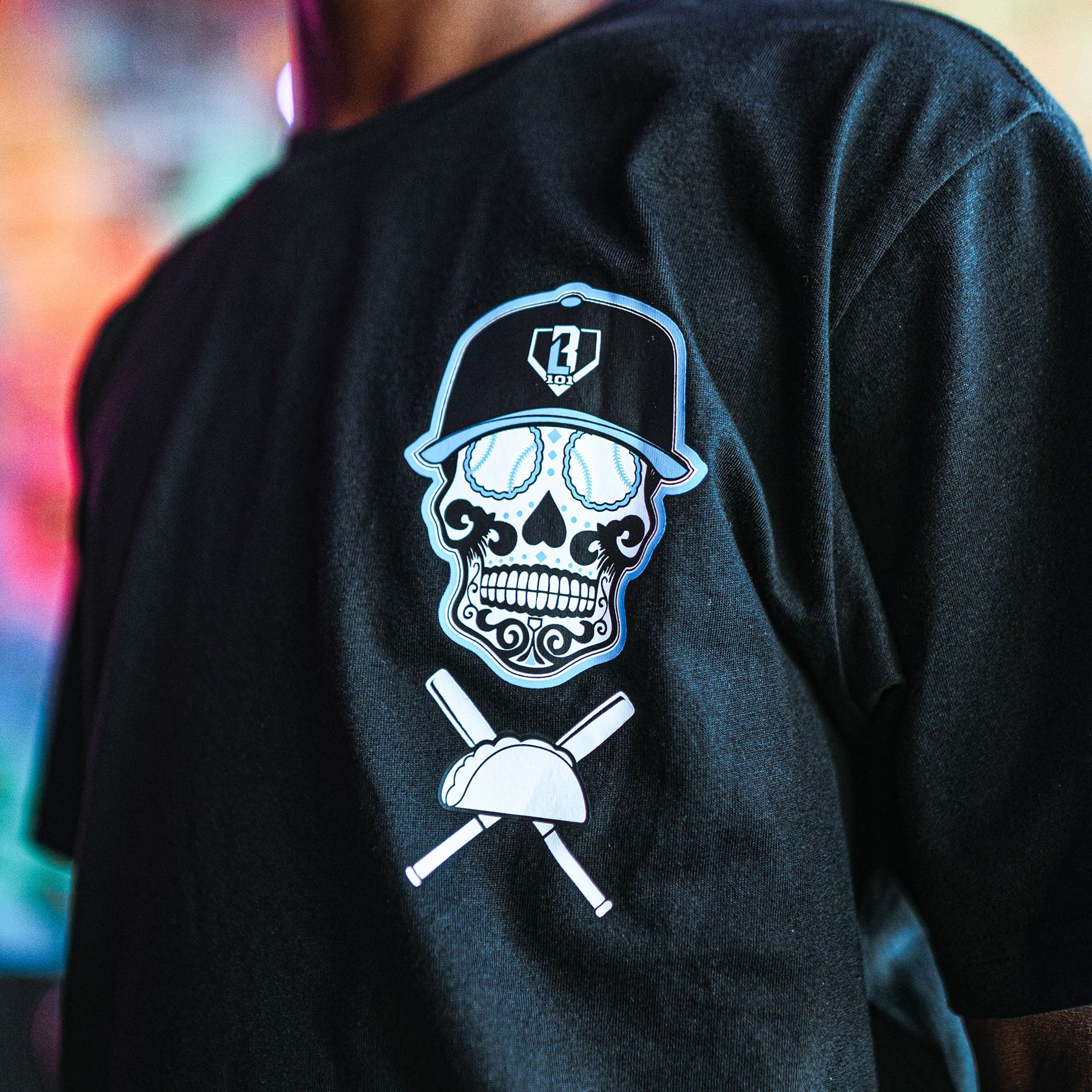 Black t-shirt with a skull and crossbones design on the back, featuring a cap and baseball bat.