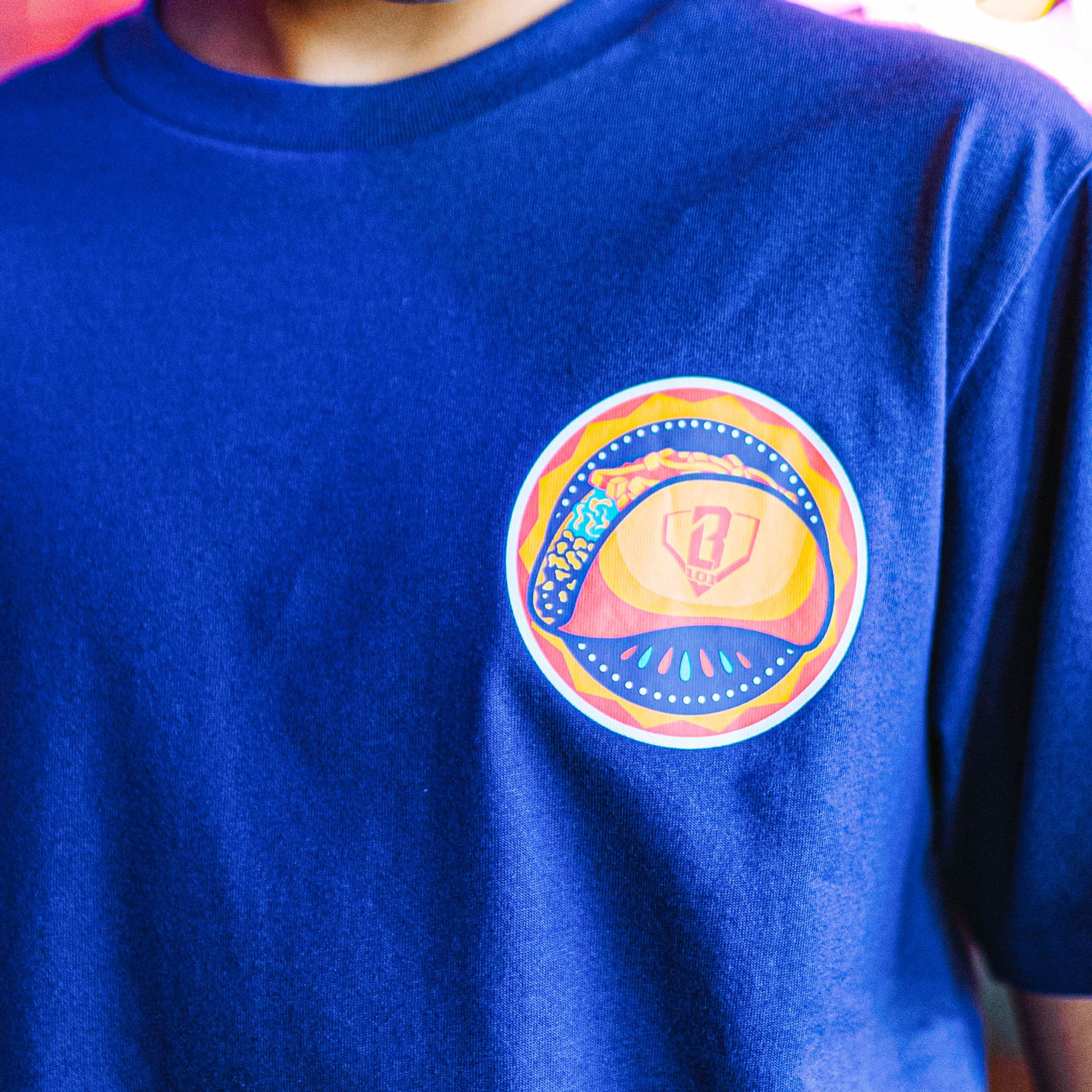 Purple t-shirt with a colorful taco graphic design on a person wearing it.