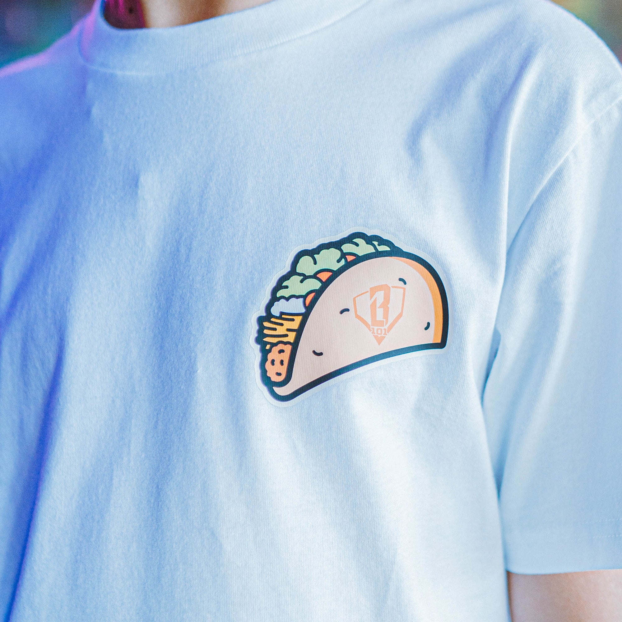 White t-shirt with a cartoon taco BL101 design on the chest.