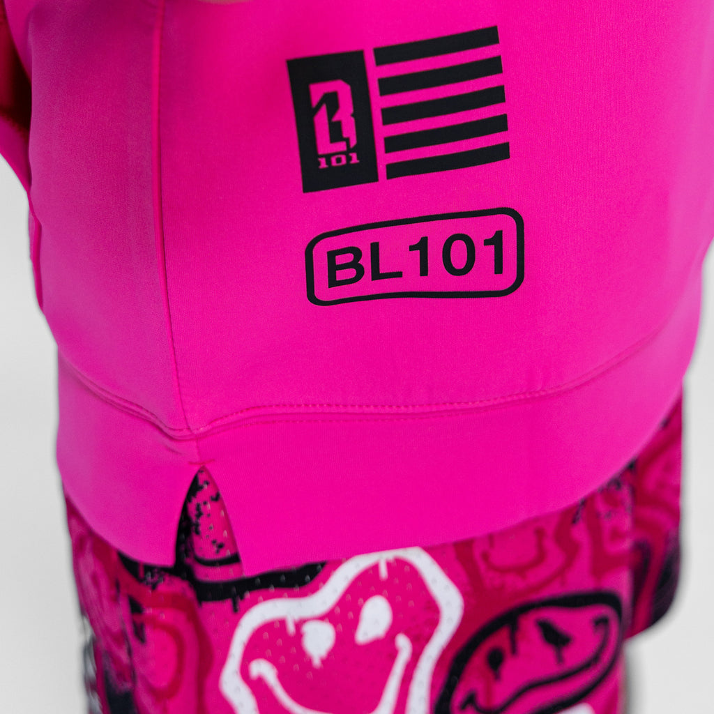 Close-up of a bright pink jacket with a BL101 logo and text on a white background