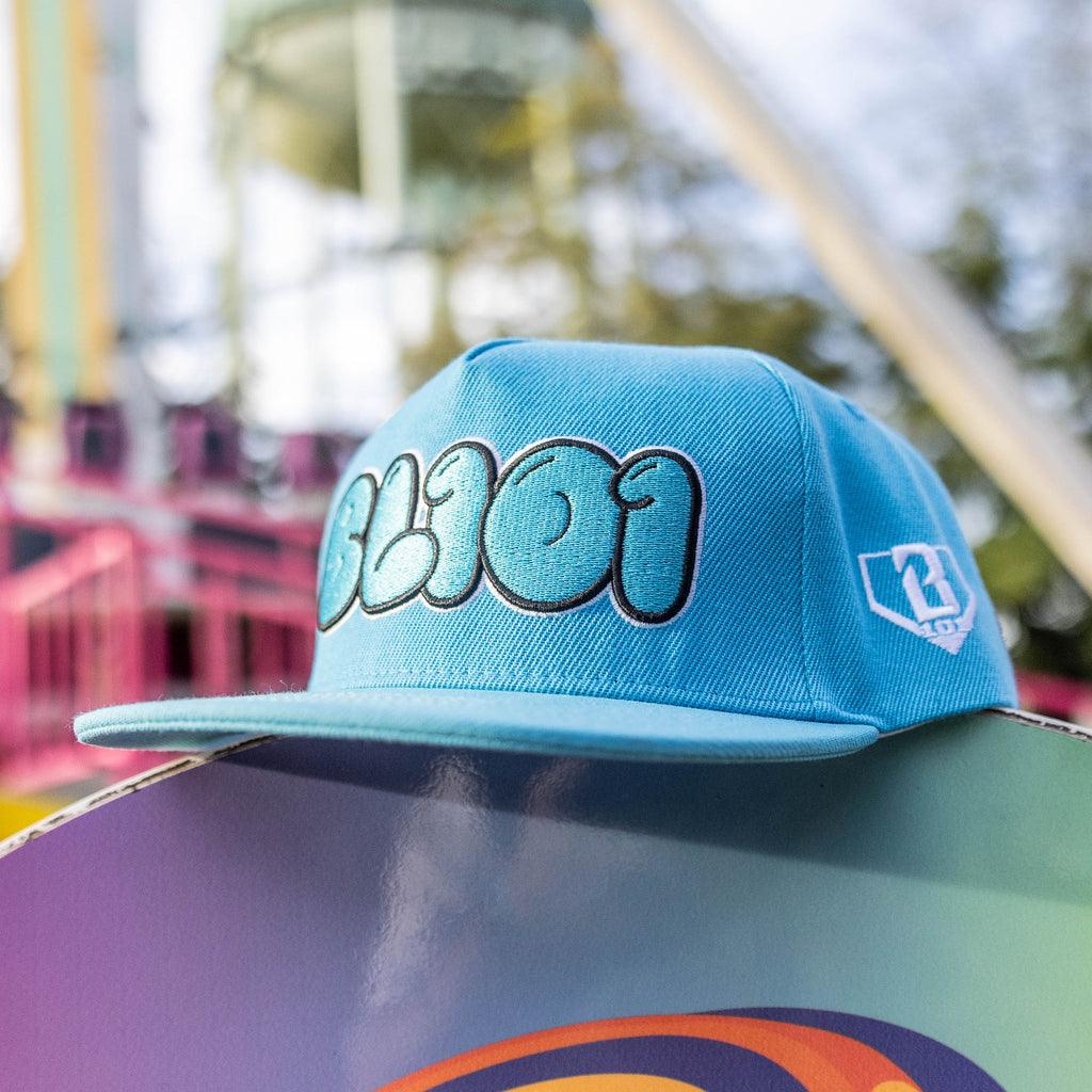 Blue cap with a BL101 logo on a colorful surface with a blurred background