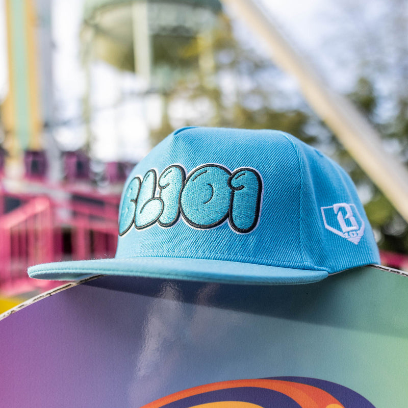 Blue cap with a BL101 logo on a colorful surface with a blurred background