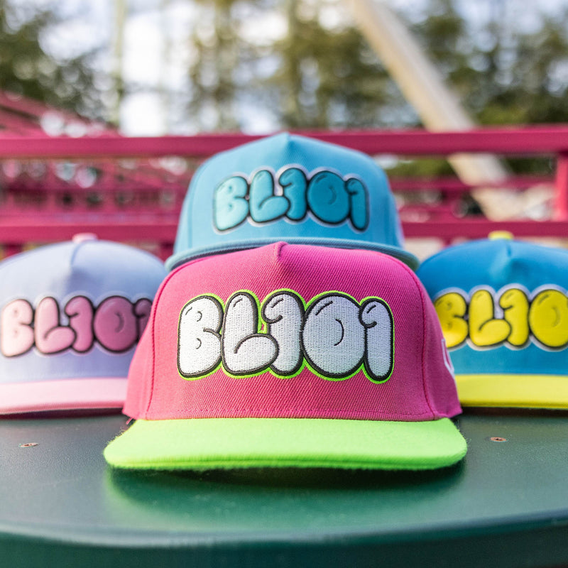 Colorful caps with 'BL101' text on a green surface with a blurred background