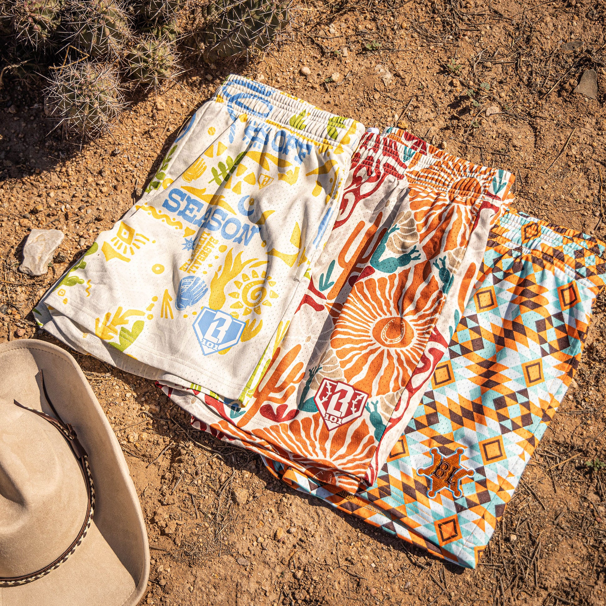 Colorful desert patterned shorts on a sandy surface with a cowboy hat.