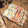 Colorful desert patterned shorts on a sandy surface with a cowboy hat.