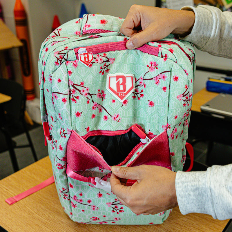 Green backpack with "Cherry Blossoms SZN 2" design — back view