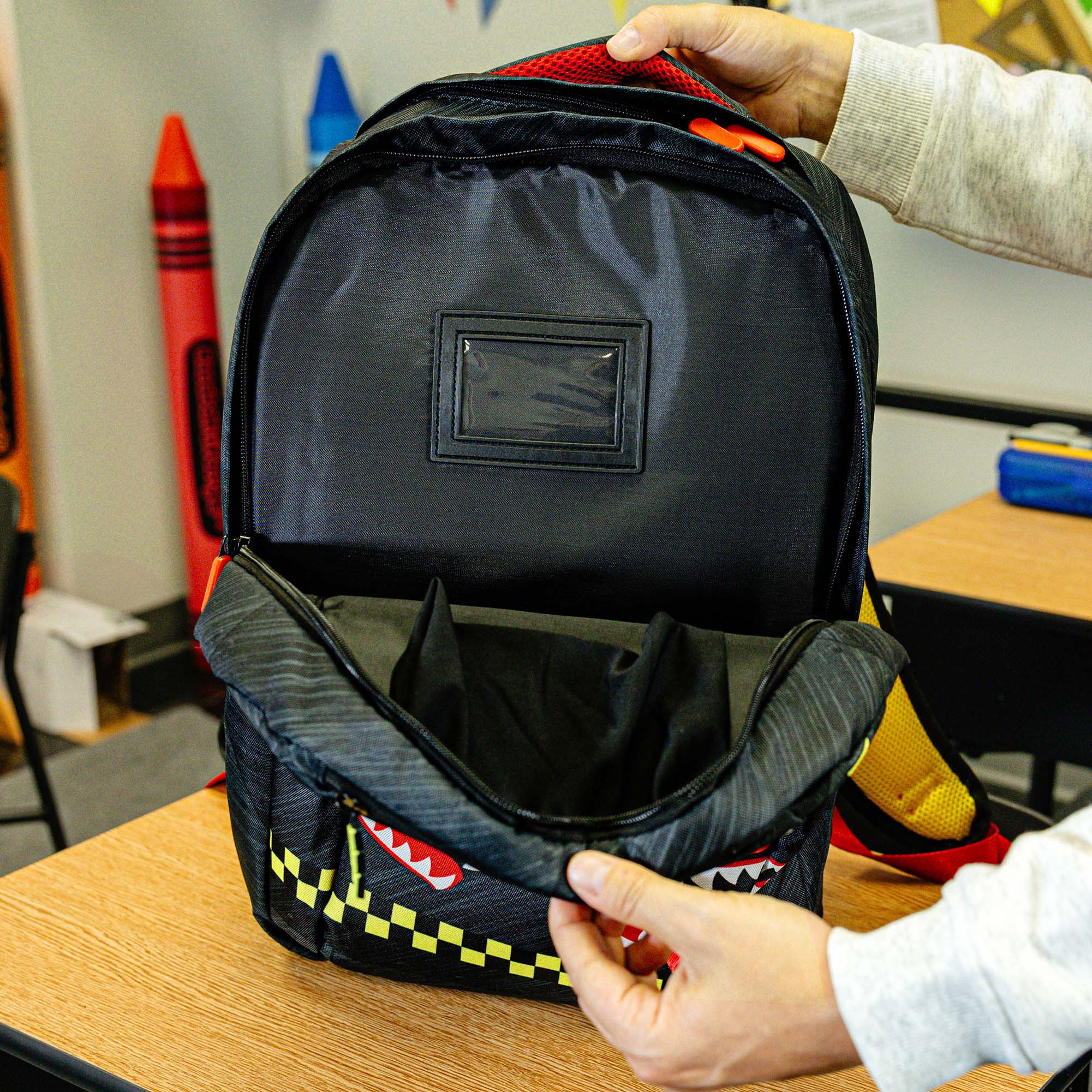 Adult model wearing multi-color backpack with "Unit 101 SZN 2" design